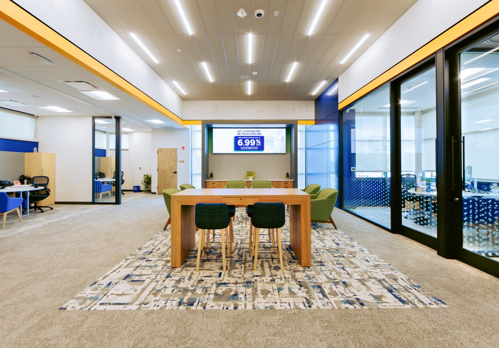 Linear recessed lights over a customer waiting and conference area at a credit union.